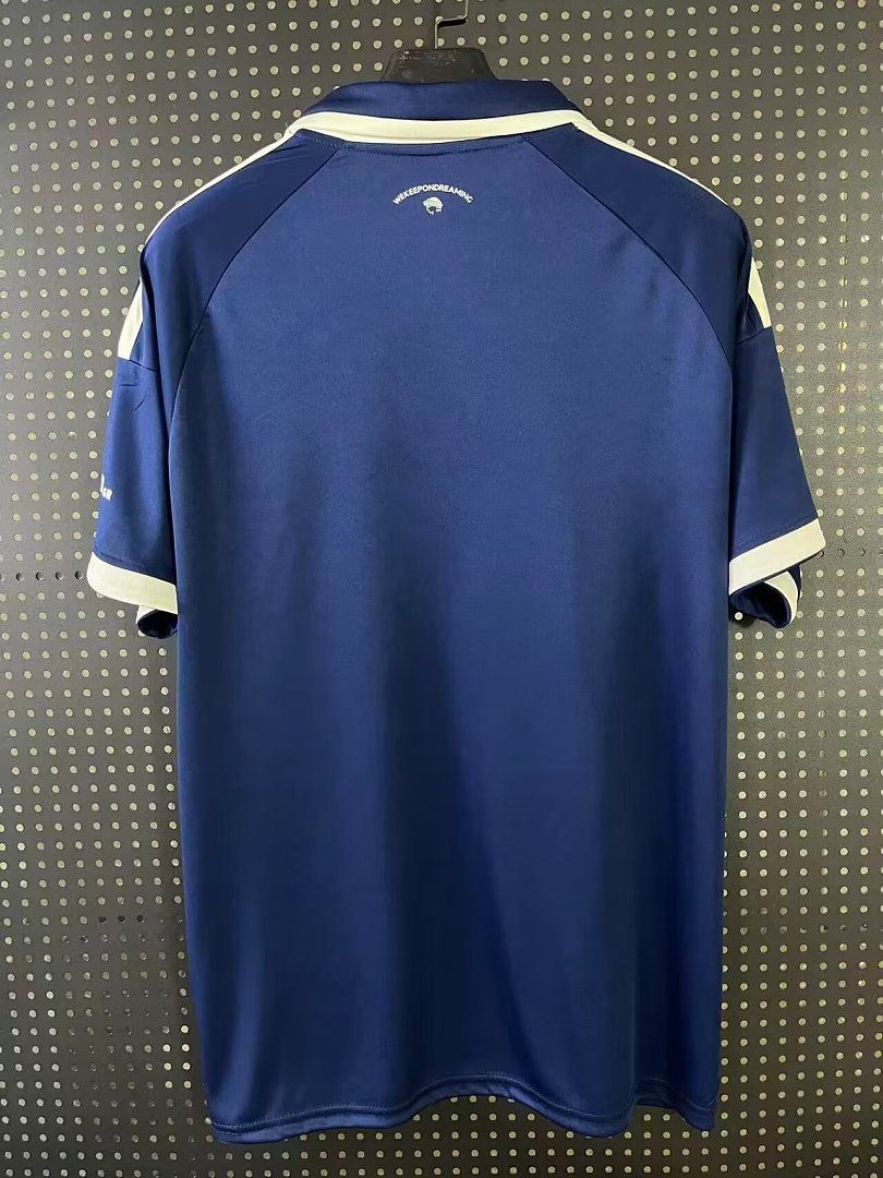 Camiseta olympiacos azul ajedrez polo 2026 2027 vista trasera